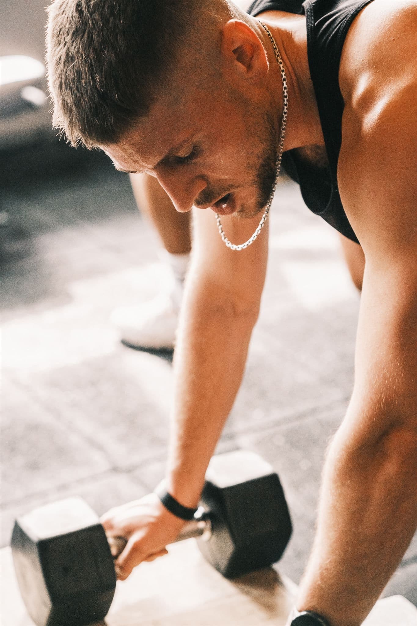 Mann macht Liegestütze mit Kurzhanteln im Fitnessstudio