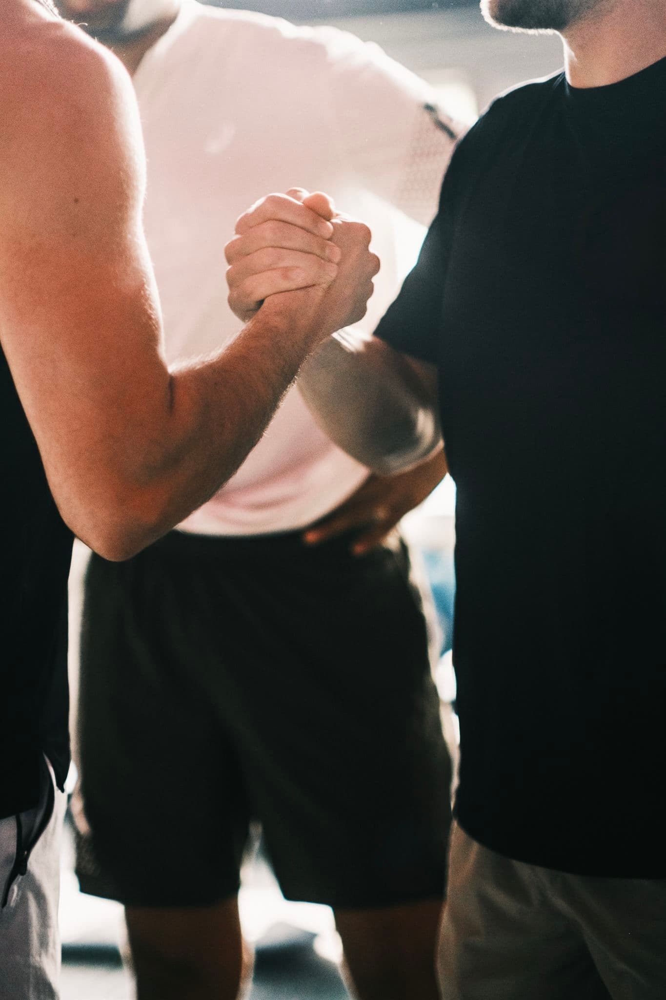 Zwei Personen geben sich im Fitnessstudio die Hand