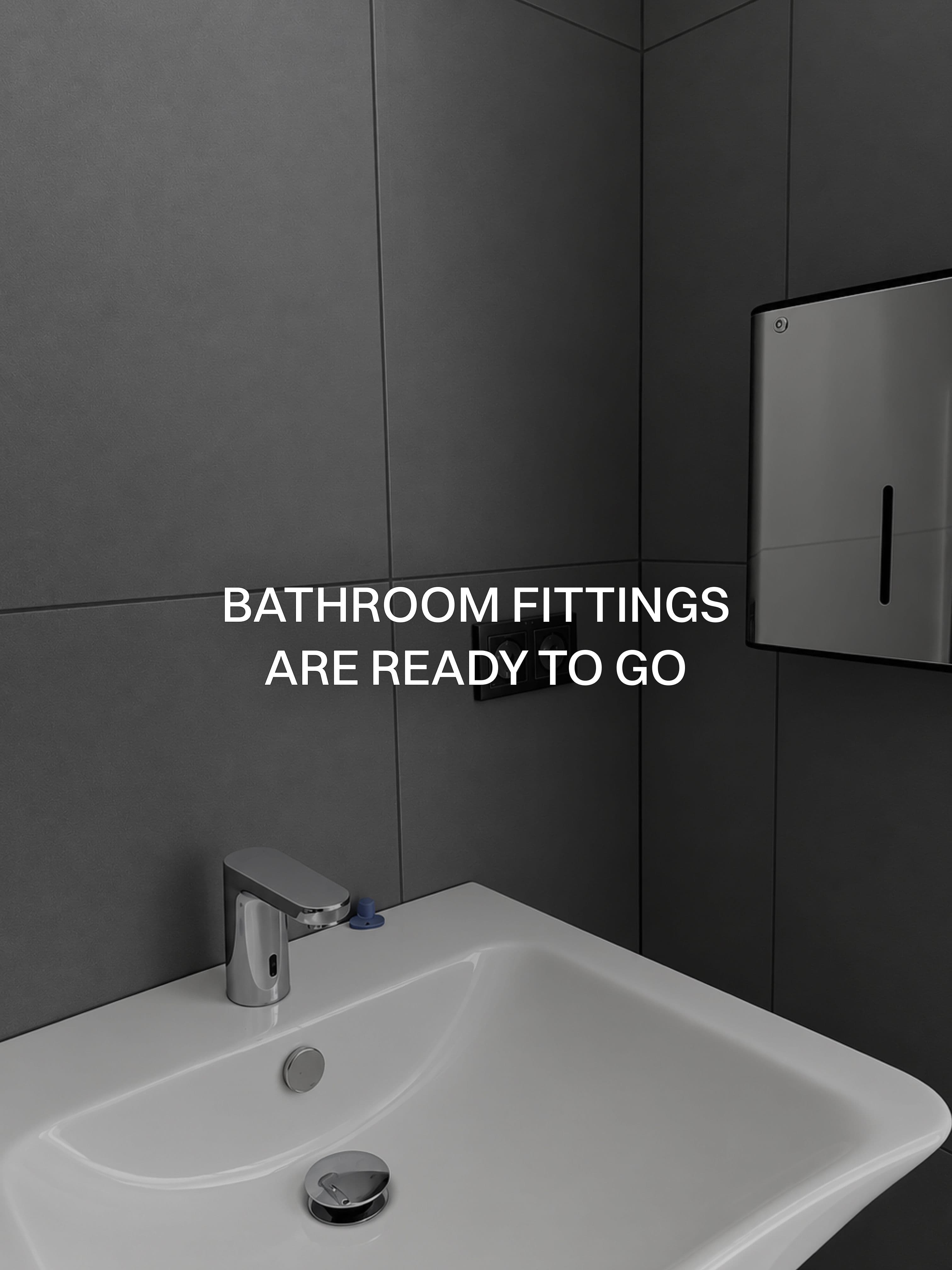 The bathroom fittings are ready: basin, tap and dispenser against grey tiles.