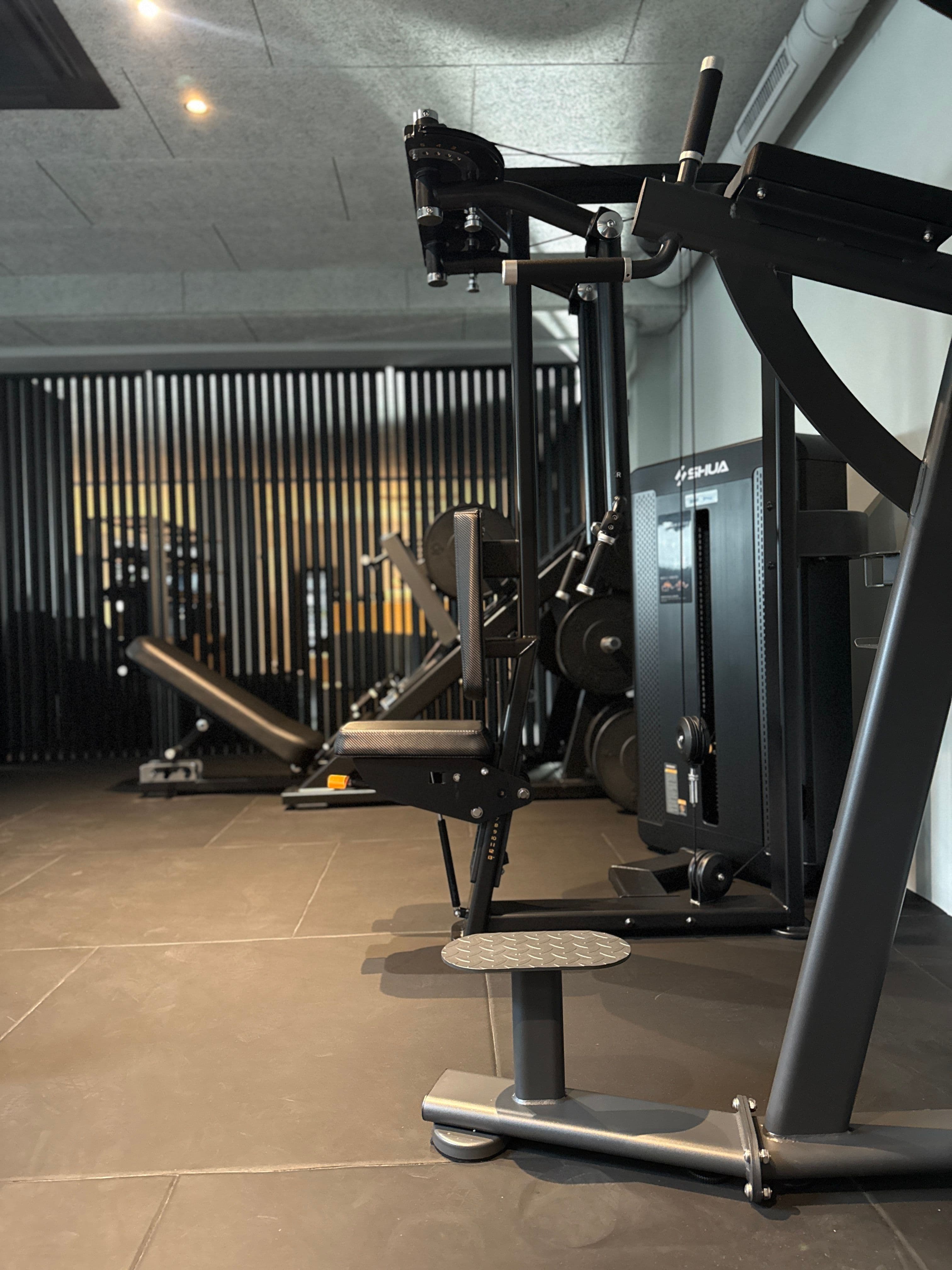 Strength machines and workout benches in the Gym Area at THE BACE.